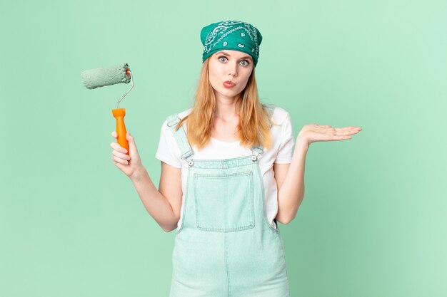 Bella donna dai capelli rossi che si sente perplessa e confusa e dubita del concetto di casa della pittura