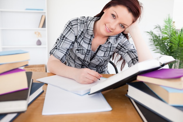 Bella donna dai capelli rossi che studia alla sua scrivania