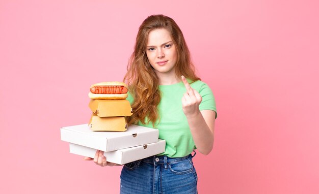 Bella donna dai capelli rossi che tiene in mano scatole di fast food da asporto?