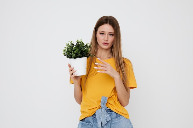 Bella donna dai capelli rossi fiore con un vaso in mano sfondo chiaro