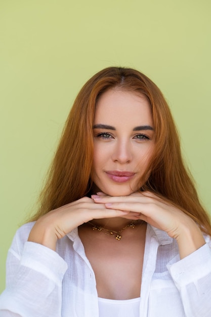 Bella donna dai capelli rossi lunghi in camicia casual su sfondo verde risata sorridente positiva godendo uscito