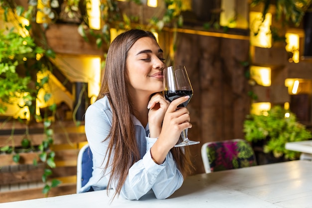 Bella donna degustazione di vino seduti al ristorante