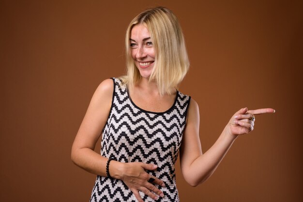 Bella donna di affari con i capelli biondi corti che indica il dito