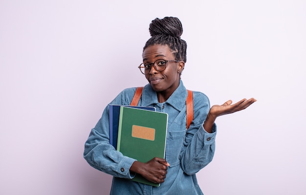 Bella donna di colore che si sente perplessa, confusa e dubbiosa. studente con il concetto di libri