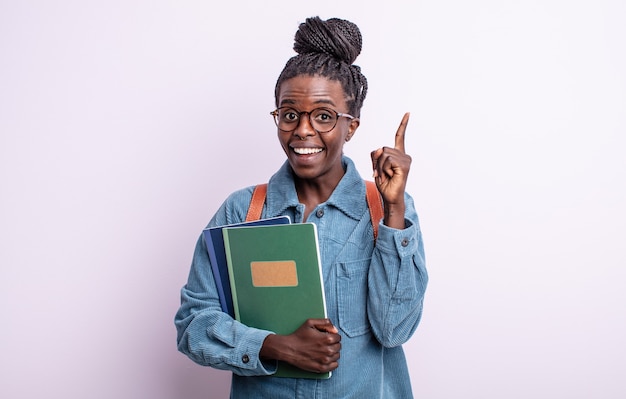 Bella donna di colore che si sente un genio felice ed eccitato dopo aver realizzato un'idea. studente con il concetto di libri