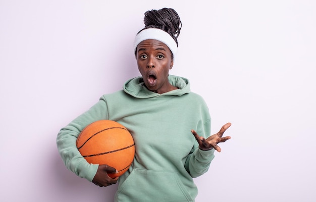 Bella donna di colore stupita, scioccata e stupita con un'incredibile sorpresa. concetto di basket