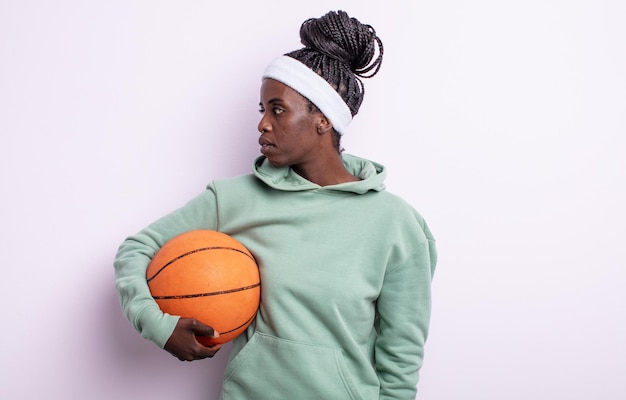Bella donna di colore sulla vista di profilo pensando, immaginando o sognando ad occhi aperti. concetto di basket