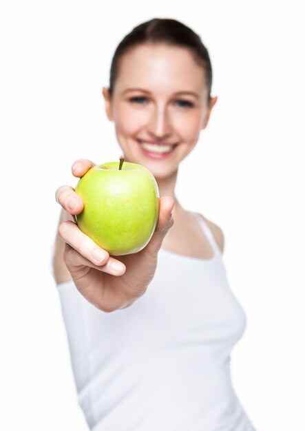 Bella donna di forma fisica che tiene mela sana su bianco