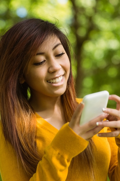 Bella donna di messaggi di testo nel parco