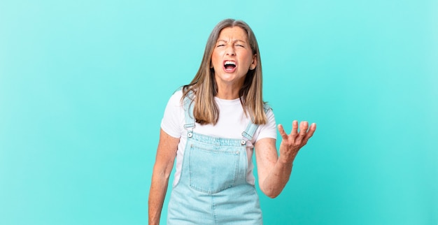 Bella donna di mezza età che sembra arrabbiata, infastidita e frustrata