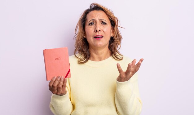 Bella donna di mezza età che sembra disperata, frustrata e stressata. concetto di agenda