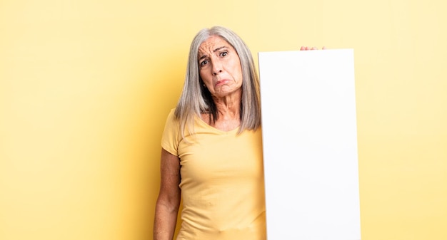 Bella donna di mezza età che si sente triste e piagnucolona con uno sguardo infelice e piange. concetto di tela vuota