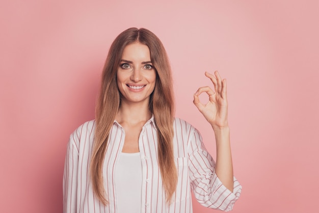 Bella donna di successo che mostra il segno ok guarda la telecamera