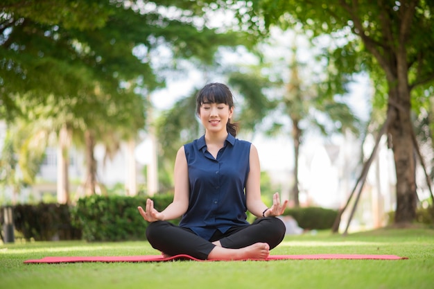 Bella donna di yoga sul parco verde