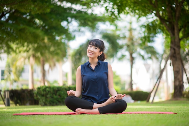 Bella donna di yoga sul parco verde