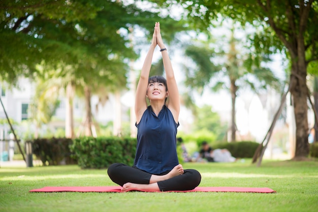 Bella donna di yoga sul parco verde