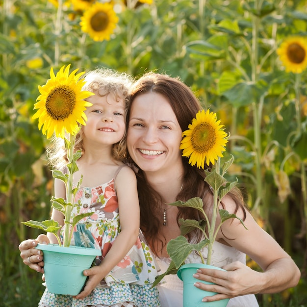 Bella donna e bambino con girasole nel campo primaverile