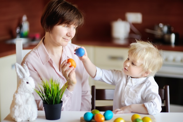 Bella donna e suo figlio carino o nipote giocando con uovo di Pasqua il giorno di Pasqua