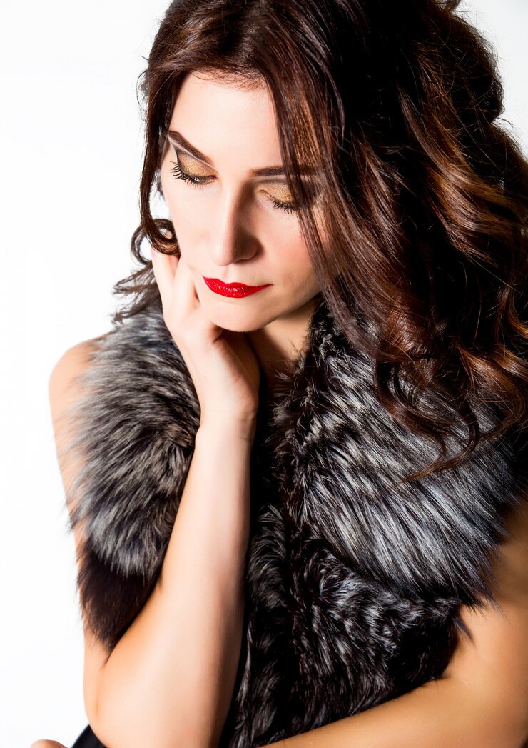 Foto bella donna elegante in abito e collo di pelliccia su sfondo bianco