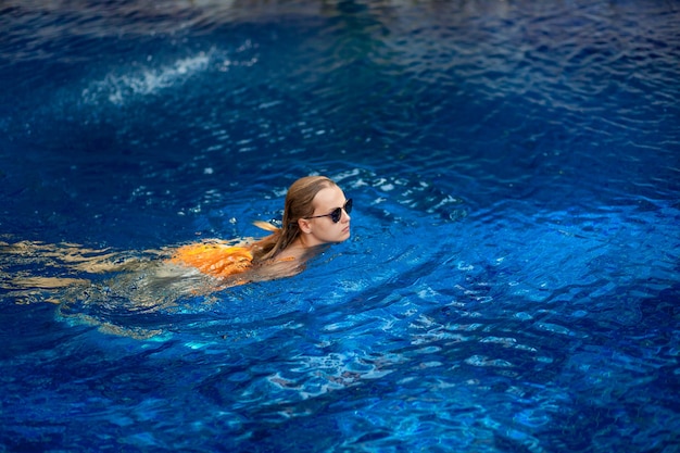 Bella donna espressiva in posa in piscina