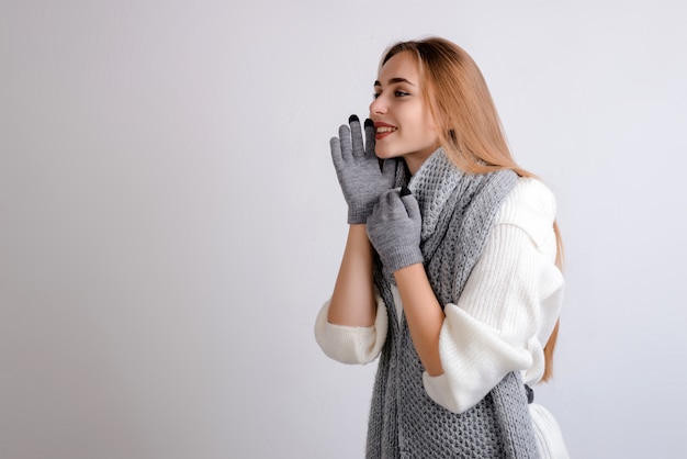 Bella donna felice che chiama qualcuno sullo spazio grigio della copia del fondo