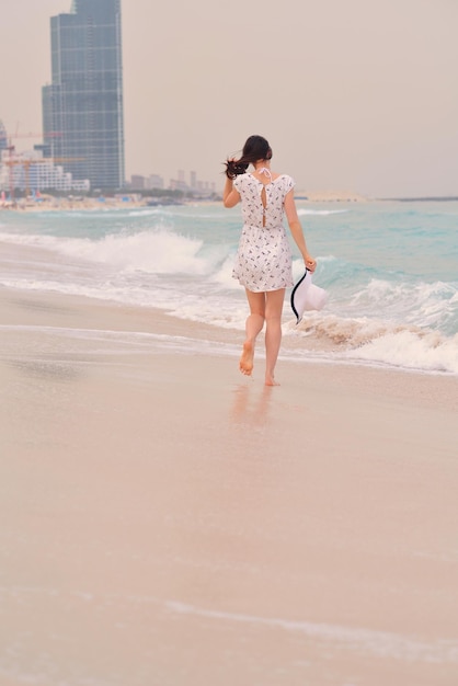 Bella donna felice che gode delle vacanze estive sulla spiaggia