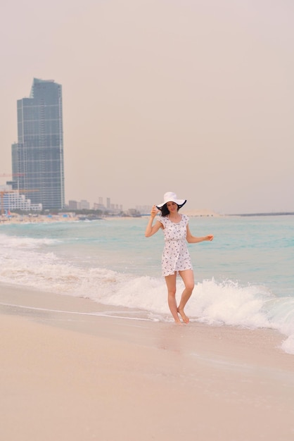 Bella donna felice che gode delle vacanze estive sulla spiaggia