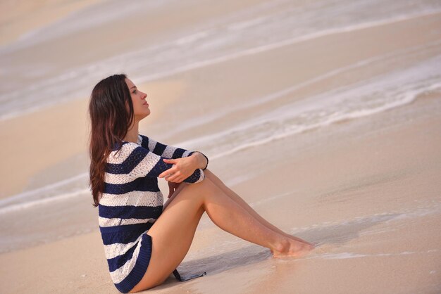 Bella donna felice che gode delle vacanze estive sulla spiaggia