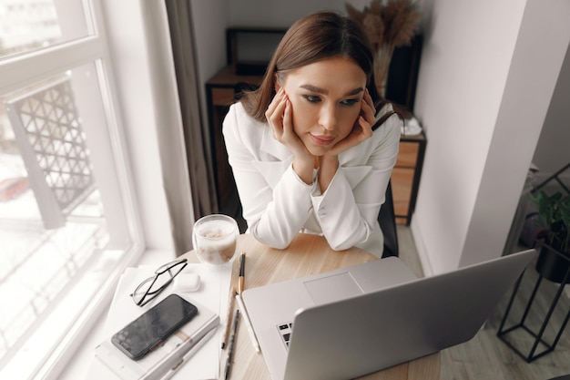 Bella donna felice che lavora con il computer portatile Donna sorridente della donna di affari in ufficio usando il computer