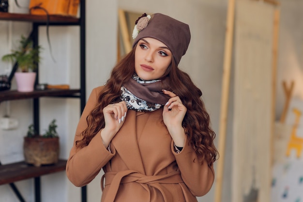 Bella donna felice che osserva obliquamente per l'eccitazione. ragazza che indossa cappello e guanti caldi lavorati a maglia.