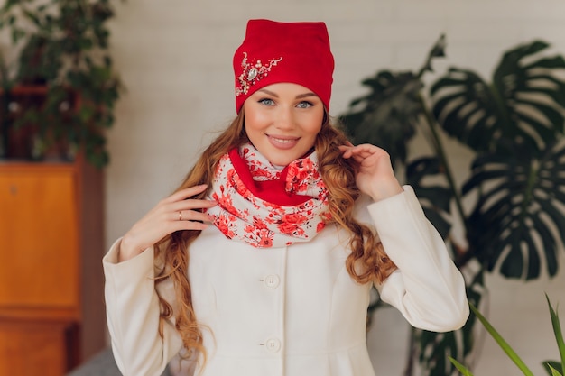 Bella donna felice che osserva obliquamente per l'eccitazione. ragazza che indossa cappello e guanti caldi lavorati a maglia.