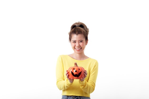 Bella donna felice che tiene una zucca in tema di halloween su priorità bassa bianca