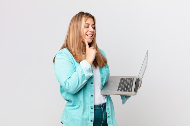 Bella donna formosa che tiene un laptop