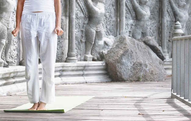 Bella donna forte che fa posa di yoga in tempio abbandonato a Bali