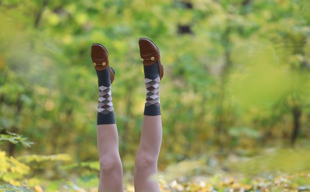 Bella donna gambe in scarpe autunnali in un paesaggio