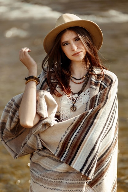 Bella donna hipster ritratto indossando cappello e poncho vestito alla moda concetto di viaggio boho sguardo sensuale