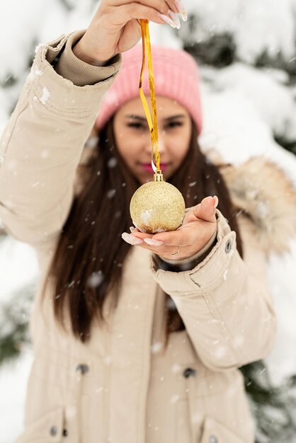 Bella donna in abiti invernali caldi che tengono decatation di natale