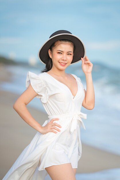 Bella donna in abito bianco in spiaggia