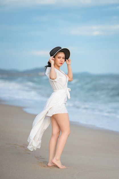 Bella donna in abito bianco in spiaggia