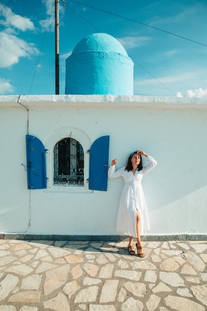 Bella donna in abito bianco vicino alla vecchia chiesa della Grecia