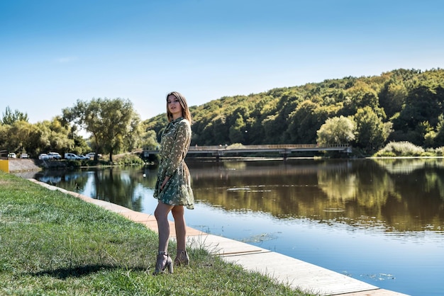 Bella donna in abito era in piedi in riva al lago rilassarsi nella natura