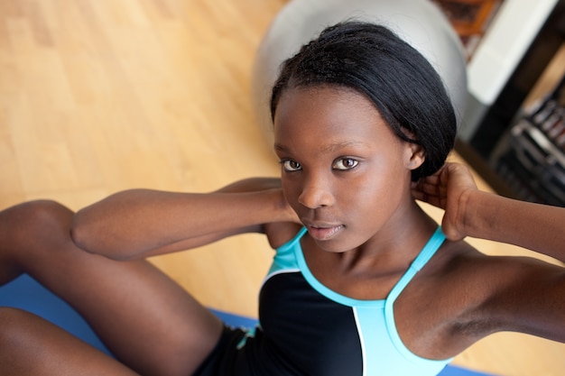 Bella donna in attrezzatura di ginnastica facendo sit-up