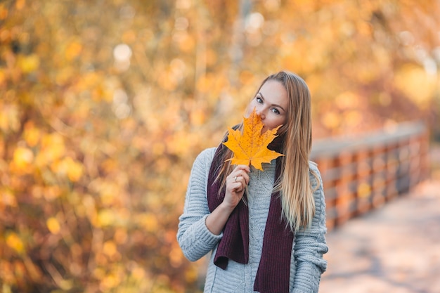 Bella donna in autunno parco sotto la caduta delle foglie