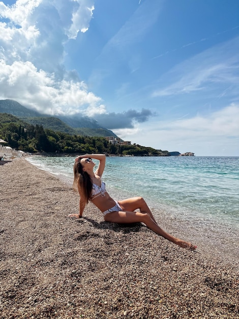 Bella donna in bikini sulla spiaggia tropicale