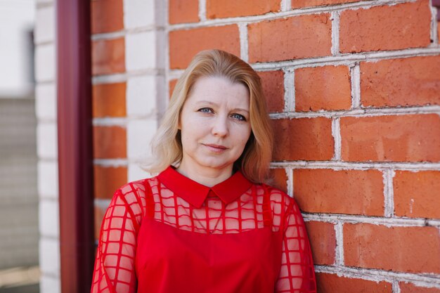 bella donna in camicia rossa. rughe sul viso della donna. bionda in una camicetta rossa. una bella mamma