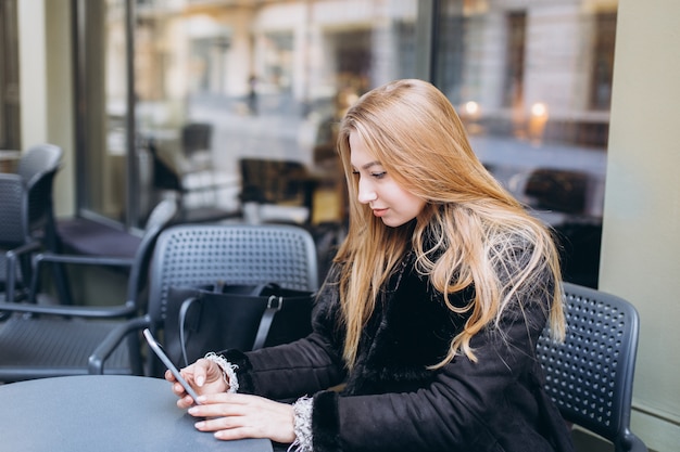 Bella donna in città con lo smartphone in chat nei social media