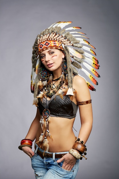 Bella donna in costume nativo americano con piume