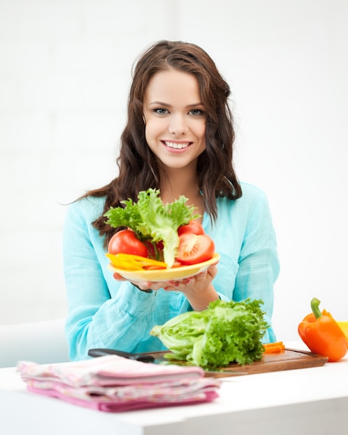 bella donna in cucina a tagliare le verdure