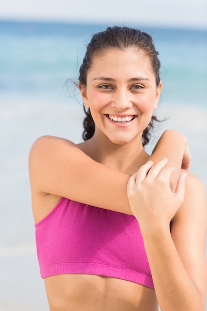 Bella donna in forma allungando il braccio