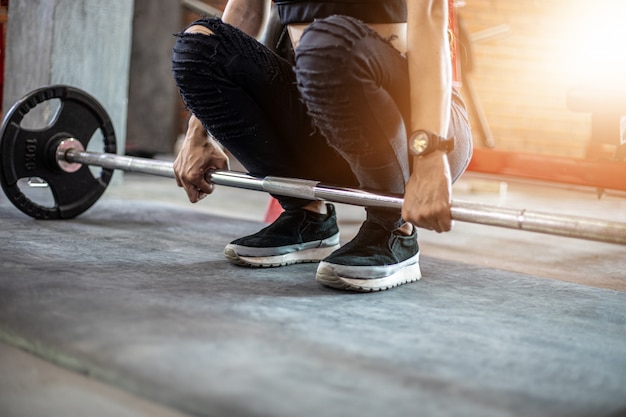 Bella donna in forma muscolare che esercita i muscoli della costruzione e fitness donna facendo esercizi in palestra. Fitness - di stile di vita sano